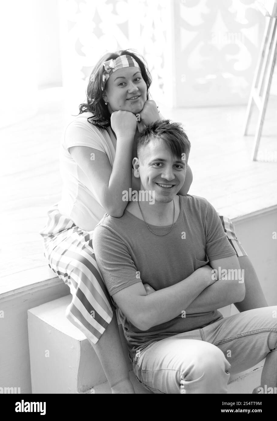 Schwarz-weiß-Porträt von glücklich schwangere Frau umarmt Mann von hinten Stockfoto