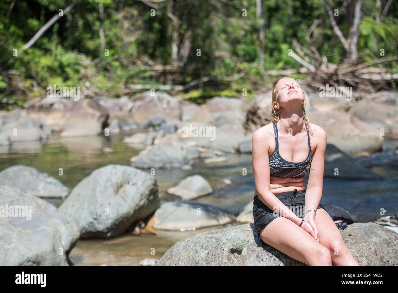 Rio Grande, Puerto Rico - 6. März 2018: Junge Frau sonnt sich in der Sonne am natürlichen Pool des Río Mameyes im El Yunque National Forest. Stockfoto