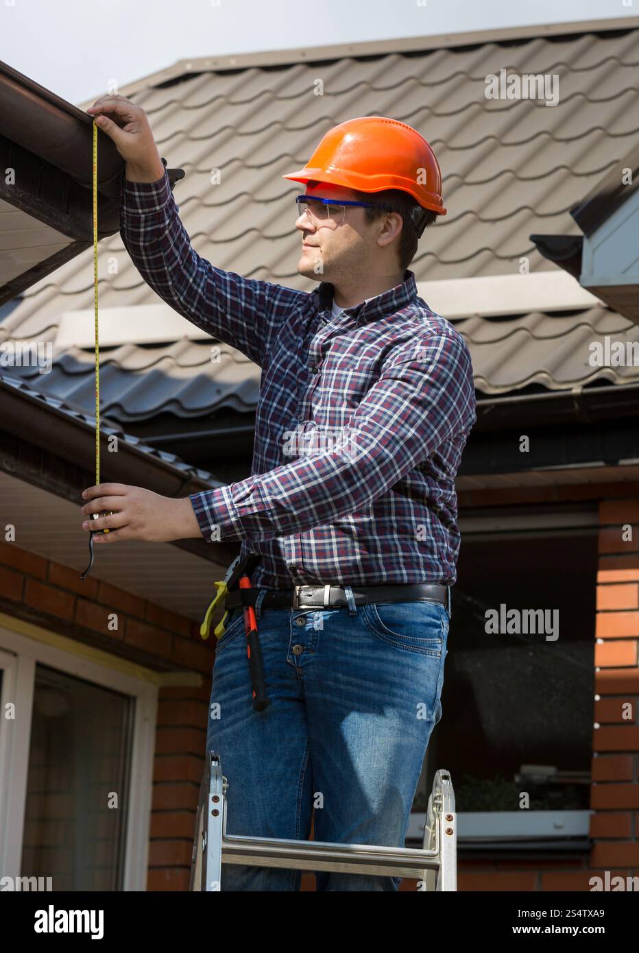 Porträt der Berufsarbeitskraft Messung der Höhe des Daches mit Klebeband Stockfoto