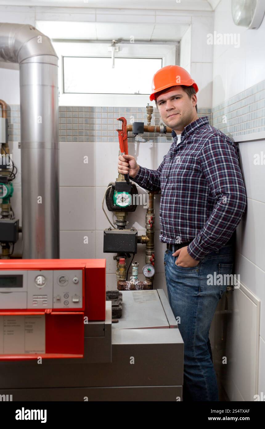 Junge Klempner Installation Heizsystems im Heizraum Stockfoto