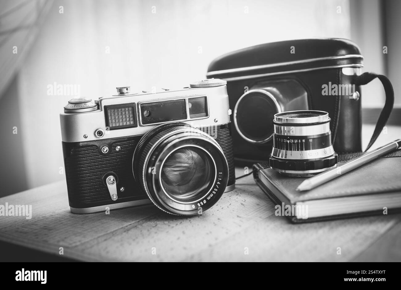 Black And White Nahaufnahme Foto der alten Kamera und Notebook auf Schreibtisch liegen Stockfoto