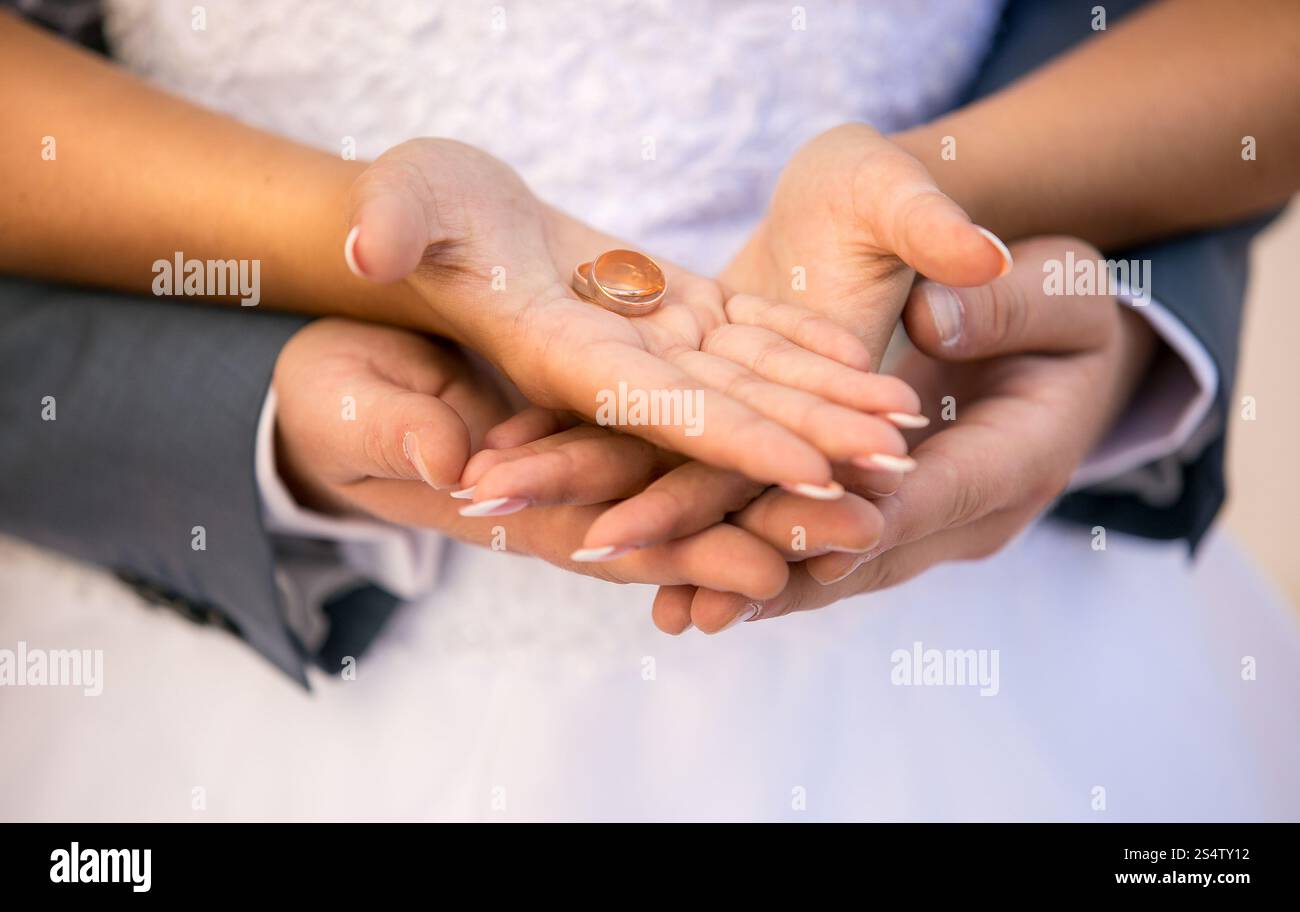 Nahaufnahme Foto von Braut und Bräutigam halten goldene Hochzeit Ringe auf Händen Stockfoto