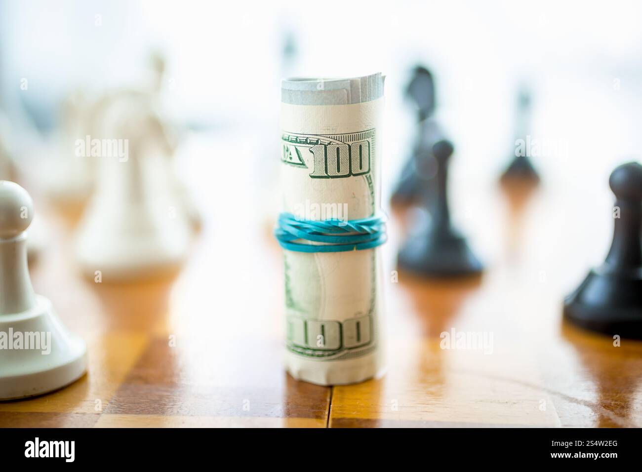 Closeup Aufnahme von verdrehten Dollar auf hölzernen Schachbrett liegen Stockfoto