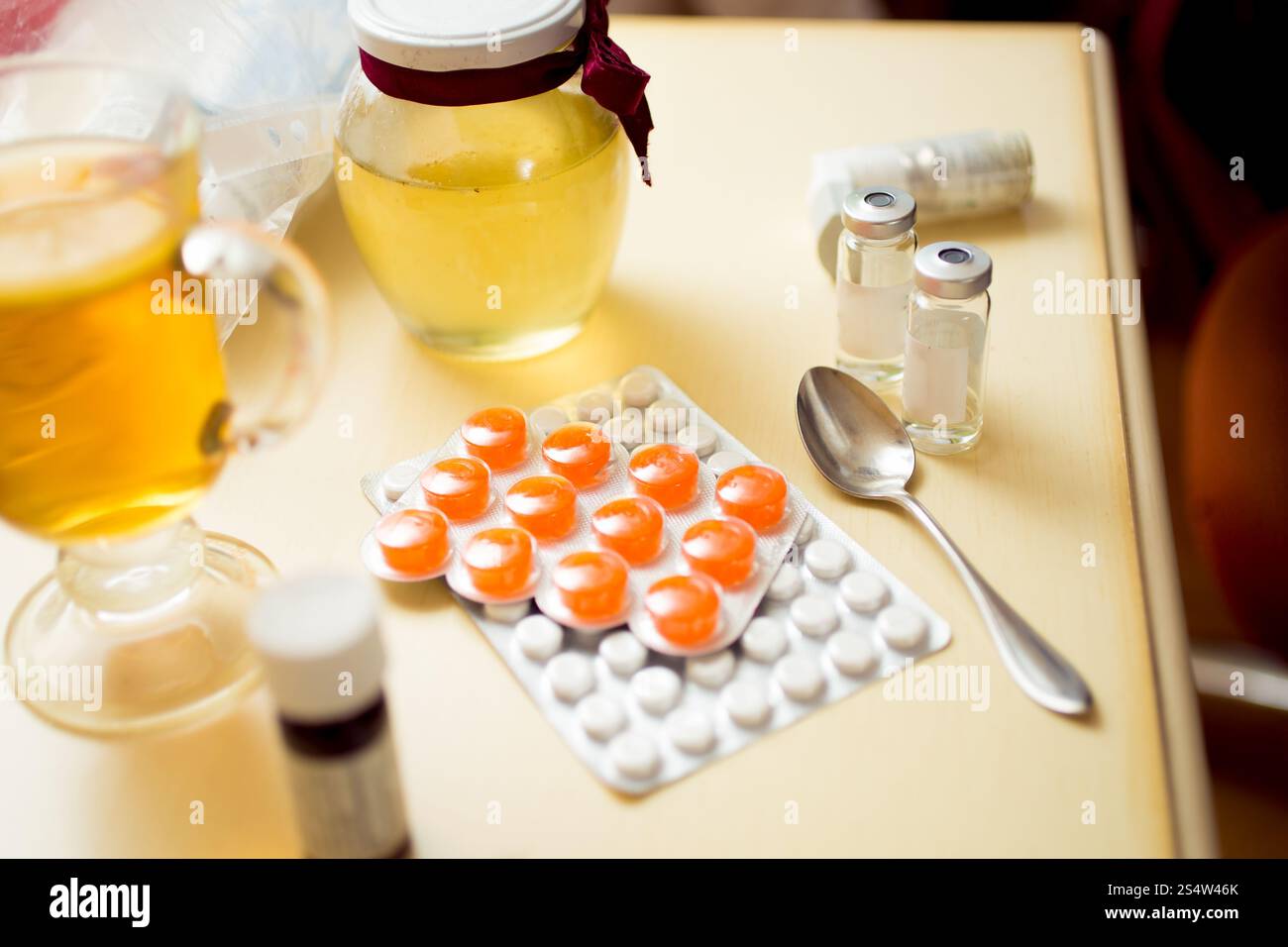 Nahaufnahme Foto von Pillen im Blister und Honig Glas auf den Nachttisch Stockfoto