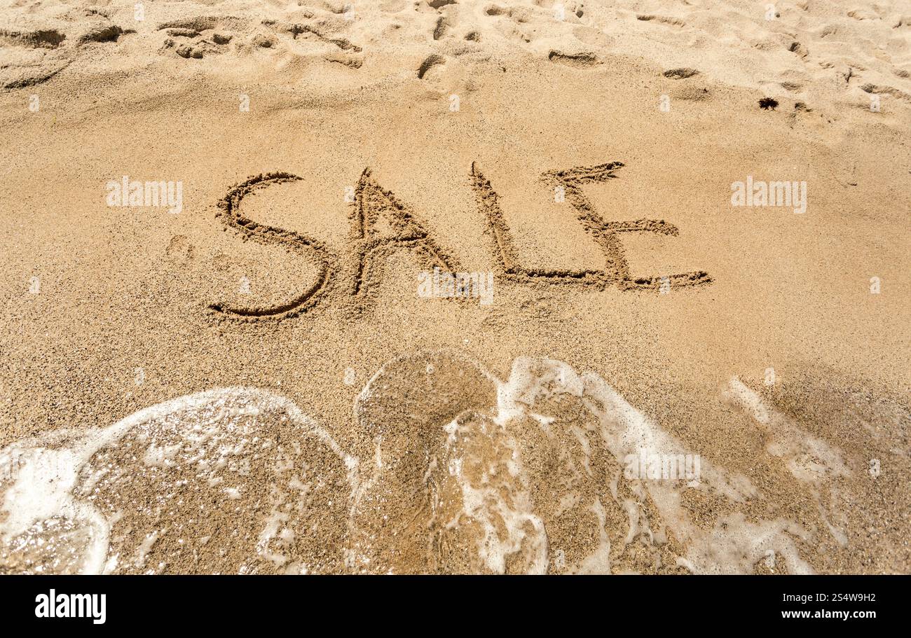 Konzeptionelle Schuss von Verkauf geschrieben am Sandstrand Stockfoto