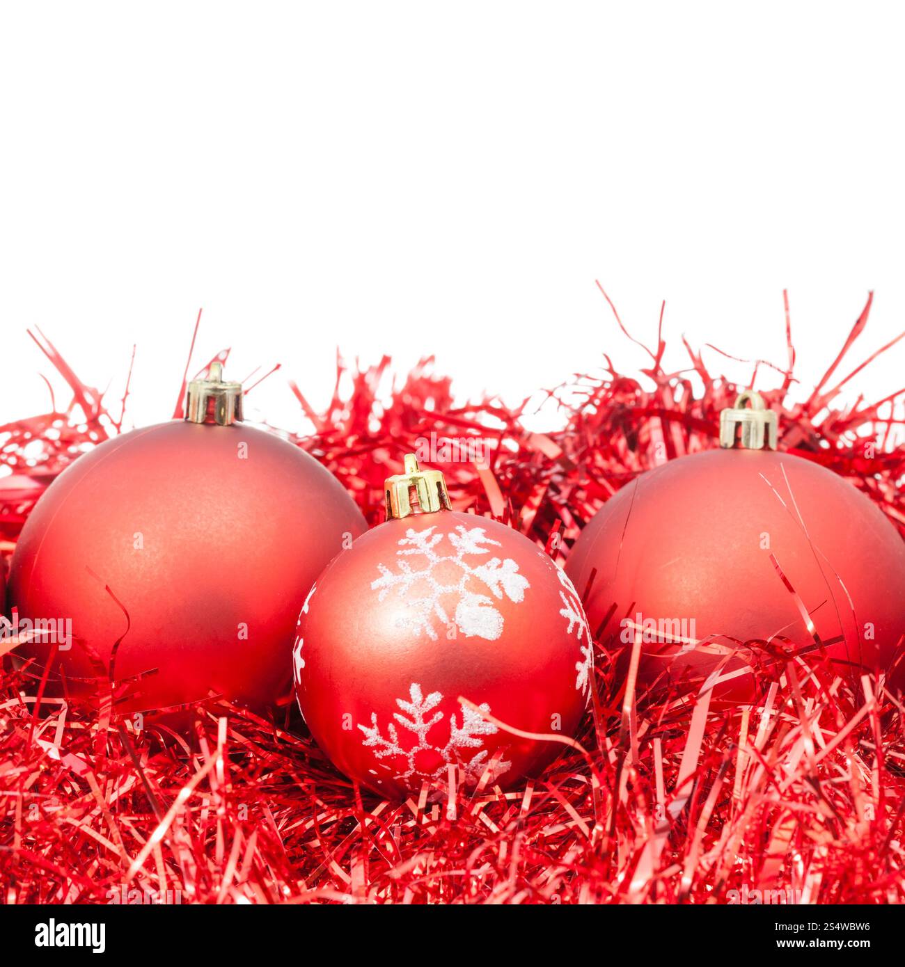 drei rote Christbaumkugeln und Lametta isoliert auf weißem Hintergrund Stockfoto