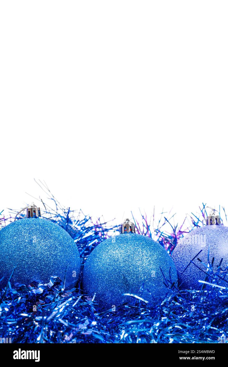 drei blaue Weihnachtskugeln auf Lametta Nahaufnahme isoliert auf weißem Hintergrund Stockfoto