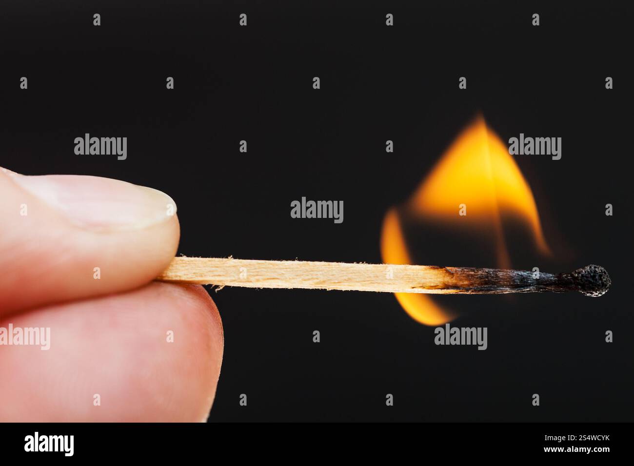 Finger mit brennendem Holz zusammenpassen nah Stockfoto