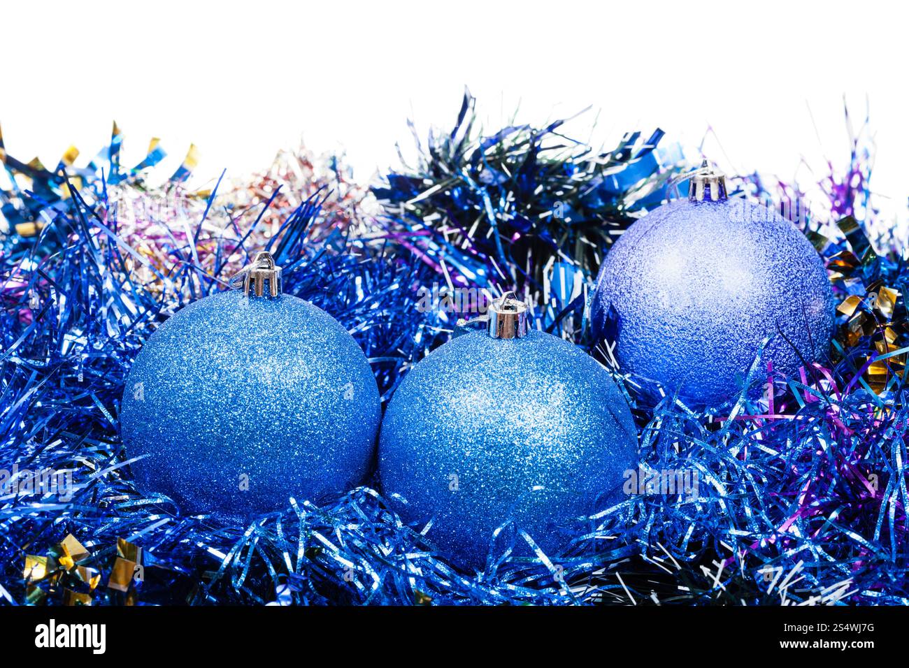 drei blaue Christbaumkugeln und Lametta isoliert auf weißem Hintergrund Stockfoto
