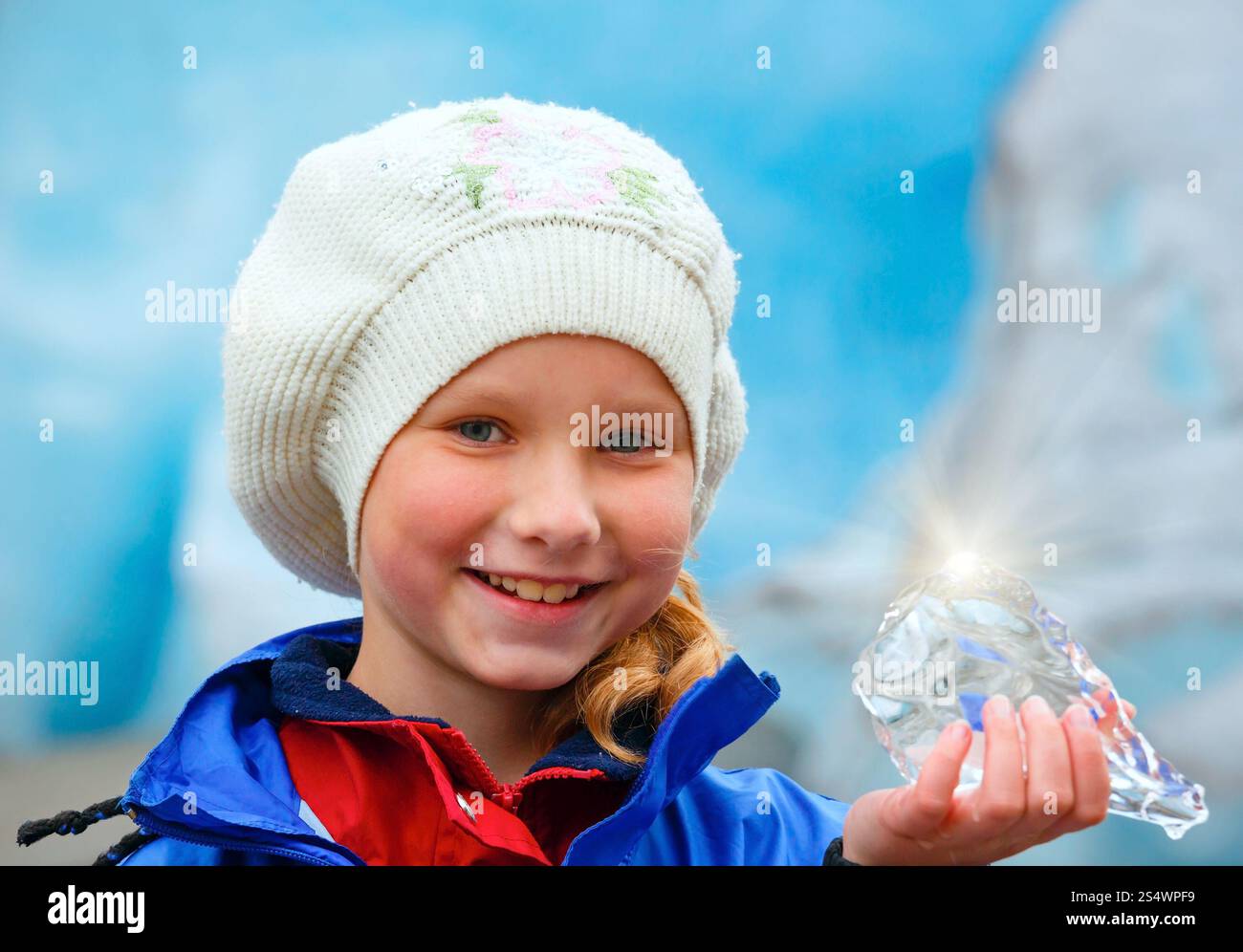 Glückliches Mädchen Porträt mit Stück Eis in der Hand am Nigardsbreen Gletscher Hintergrund (Norwegen) Stockfoto