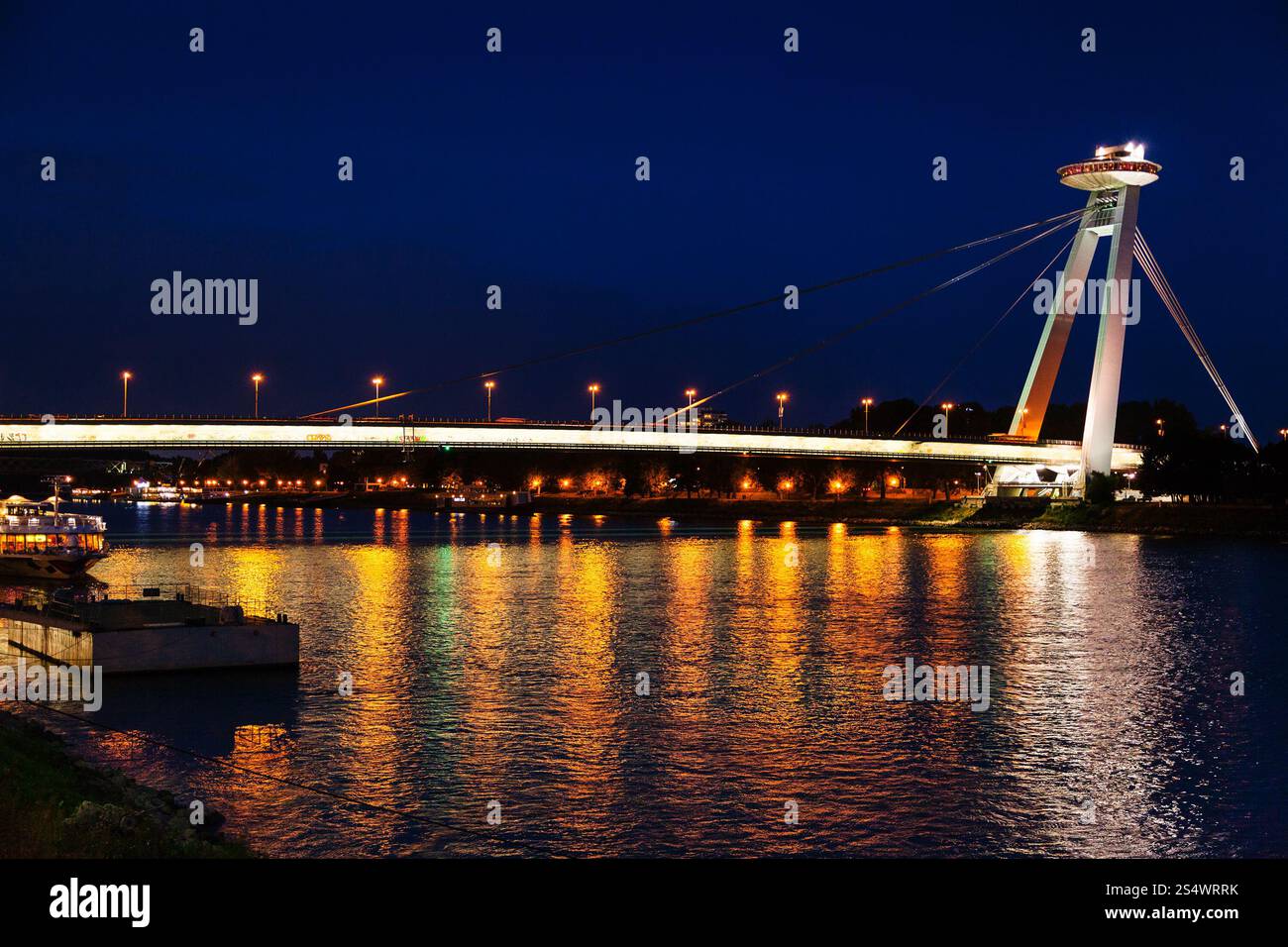 Reisen Sie nach Bratislava - nächtliche Beleuchtung der Donau von Most SNP (Brücke des Slowakischen Nationalaufstandes, UFO-Brücke, Novy Most, Neu Stockfoto