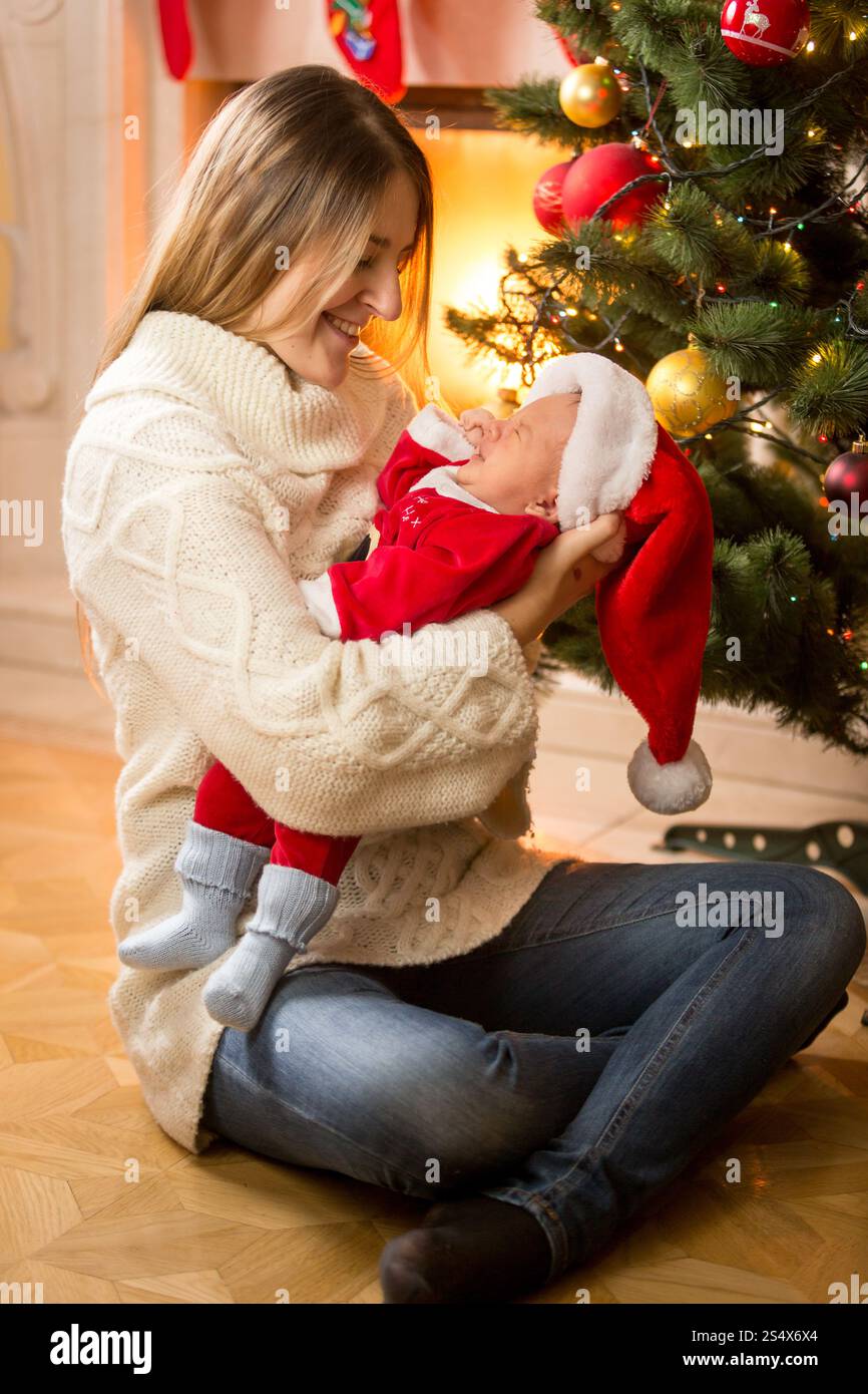 Glückliche junge Mutter mit Baby Sohn in Santa Kostüm Stockfoto