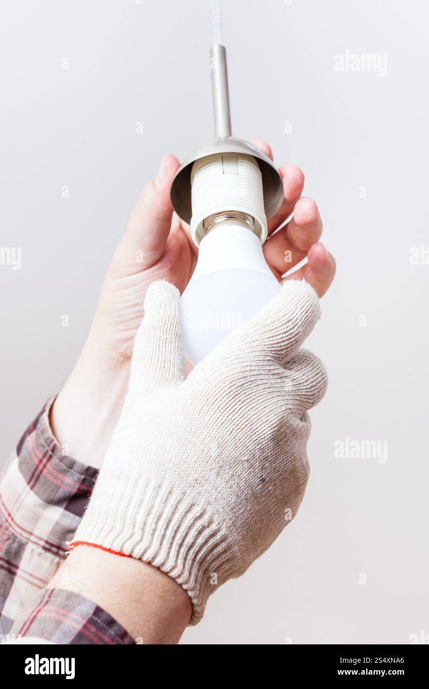 Elektriker-Halterungen neue LED-Lampe in Lampenhalter indoor Stockfoto