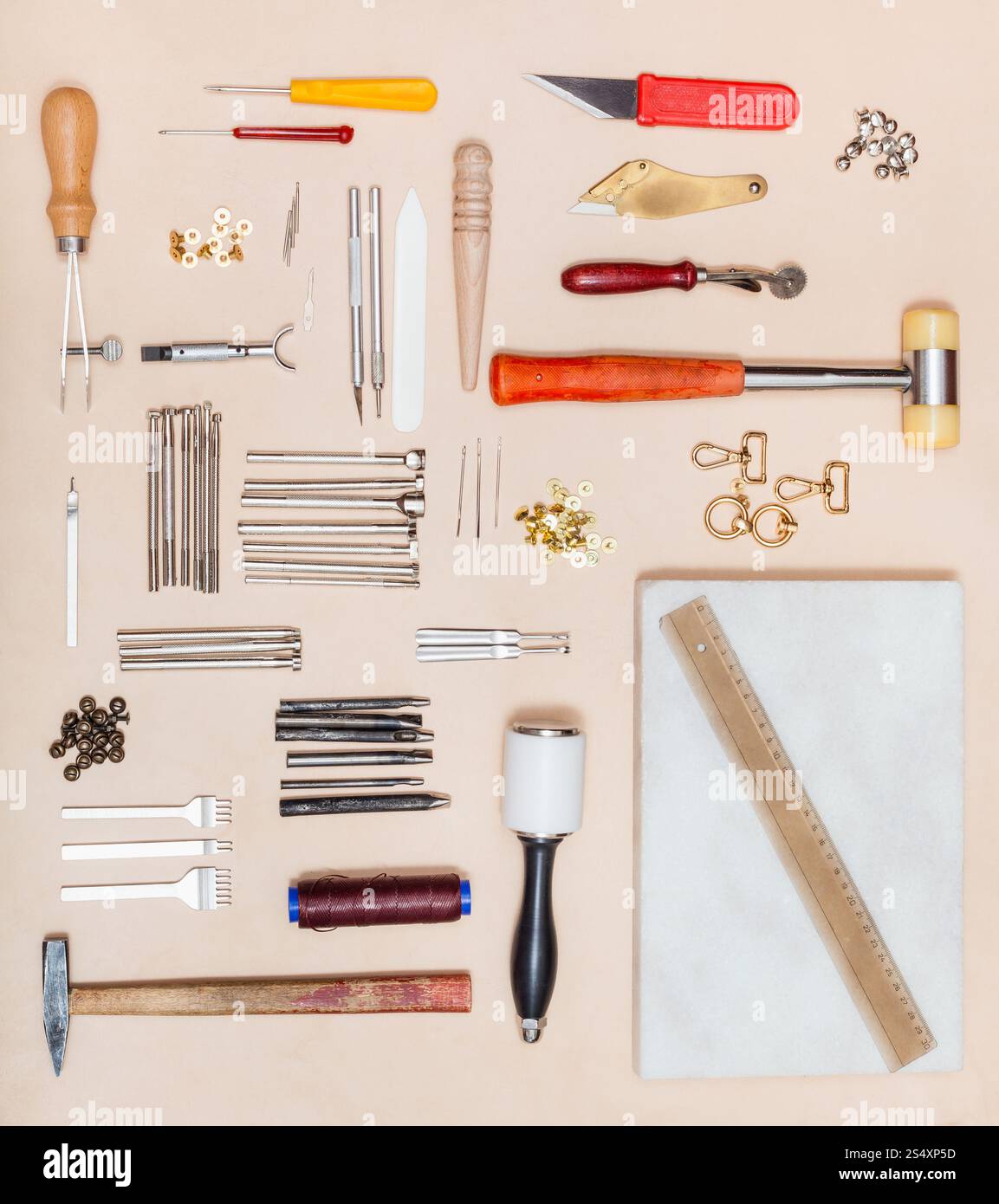 Draufsicht verschiedener Lederarbeiten Tools und Marmor Board auf Naturleder Oberfläche Stockfoto