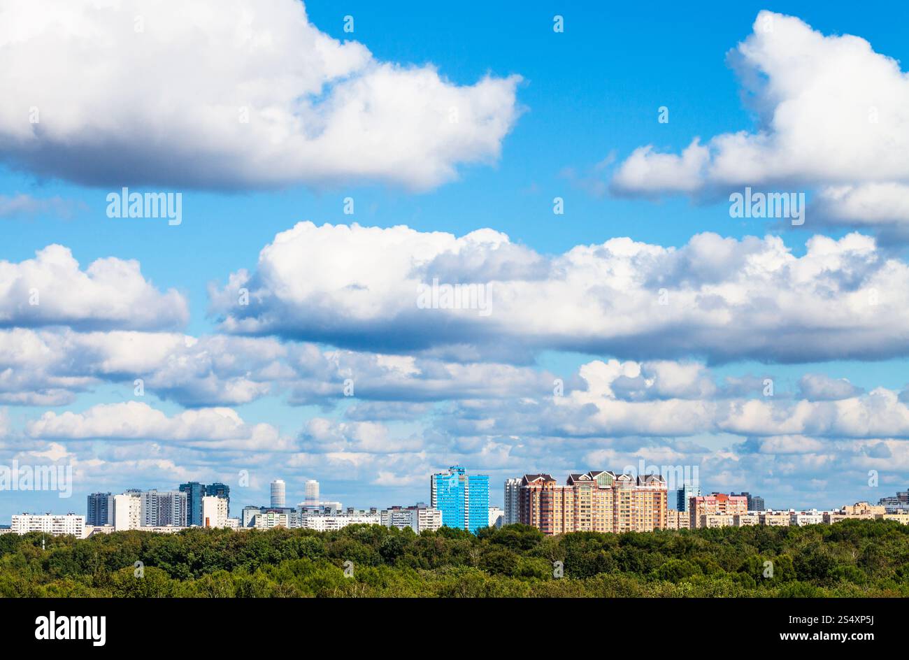 niedrige weiße Wolken am blauen Himmel über der Stadt im Sommertag, Moskau Stockfoto