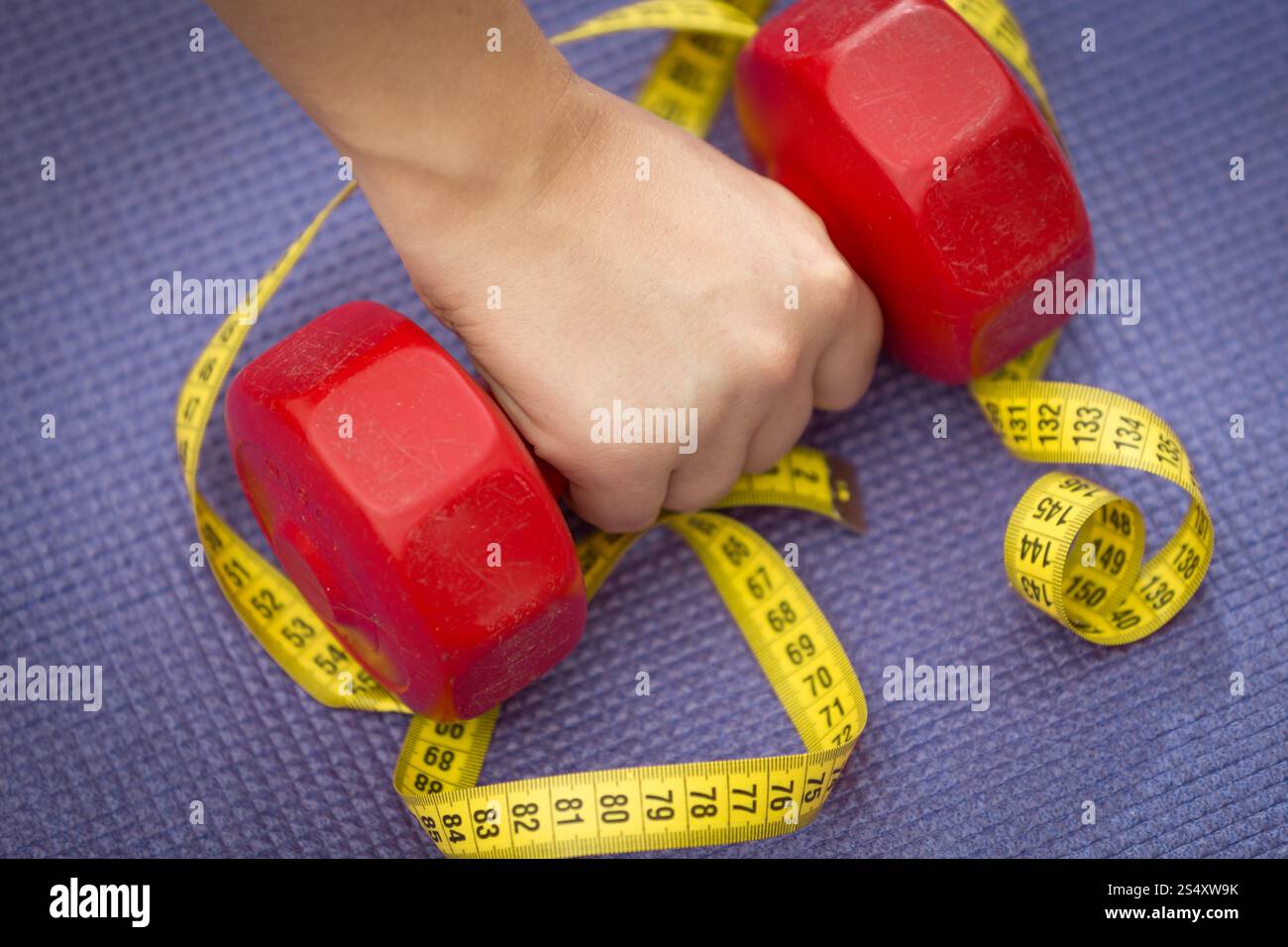 Nahaufnahme Foto von weiblicher Hand heben der Hantel am Maßband liegen Stockfoto