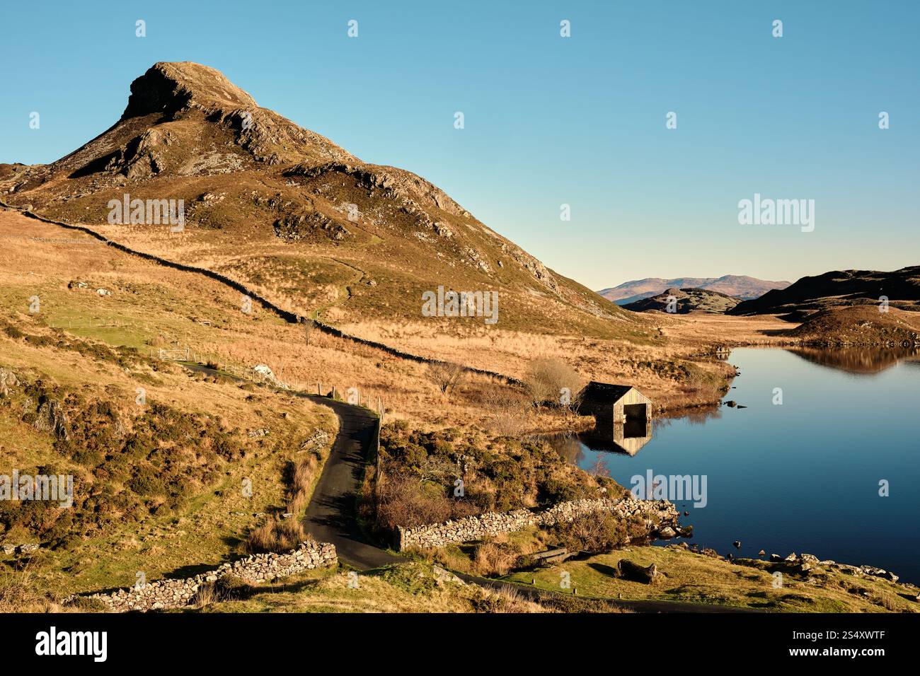 Ein Bootshaus steht am Rand der Seen von Cregennan, oder Llynnau Cregennan, in der Nähe von Arthog, Dolgellau, Nordwales mit dem Kamm von Pared y Cefn hîr Stockfoto