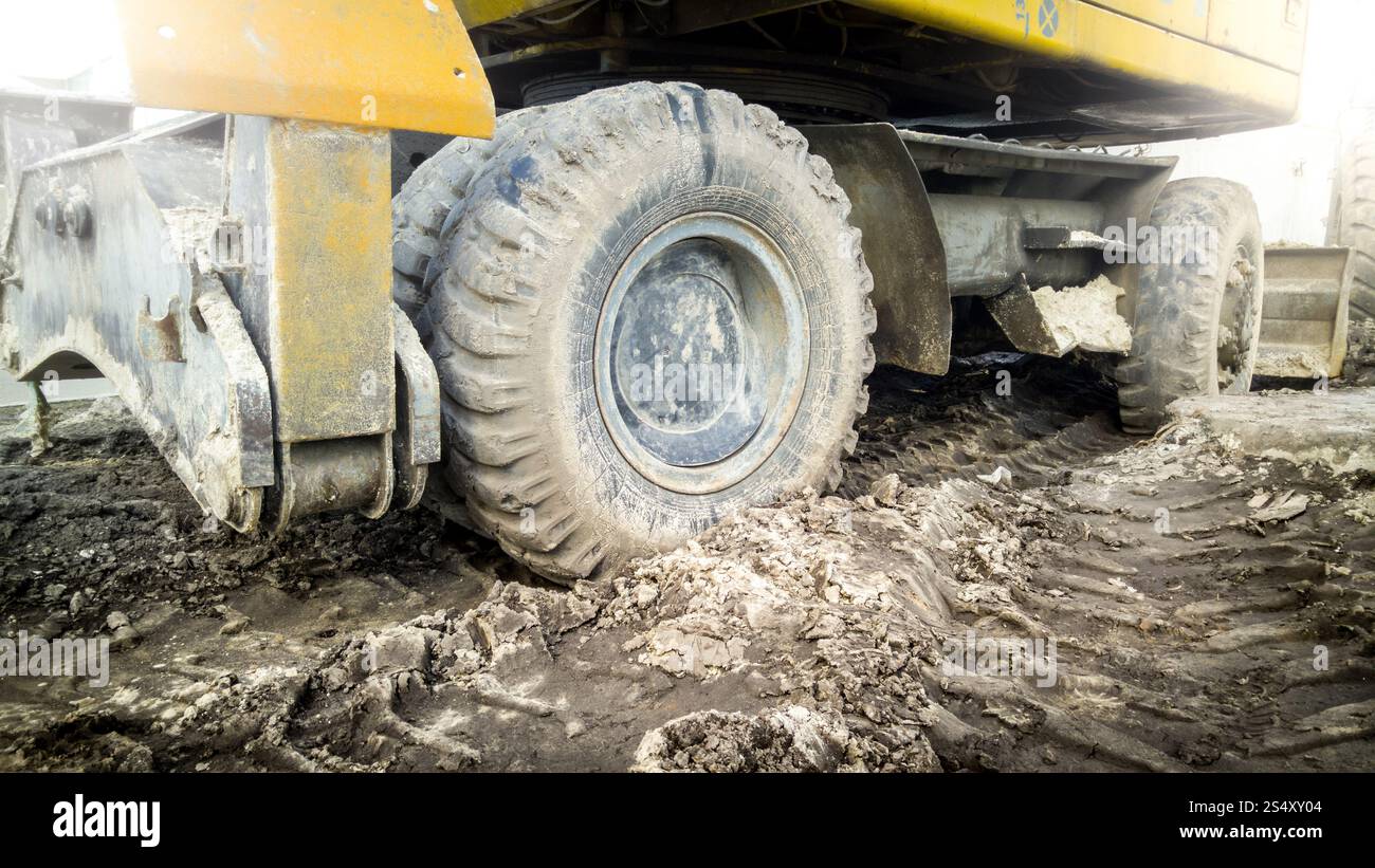 Große Bagger Räder bedeckt mit Schlamm auf der Baustelle Stockfoto