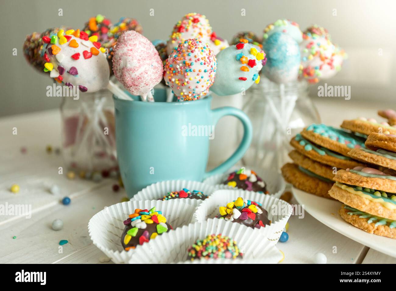 Vielzahl von dekorierten Süßigkeiten, Kuchen Pops und Cookies auf weißen Schreibtisch aus Holz Stockfoto