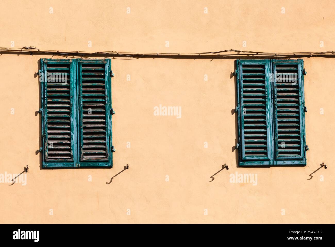 Reisen Sie nach Italien - geschlossene grüne Fenster auf gelbe Wand des alten Hauses in Florenz Zentrum Stockfoto
