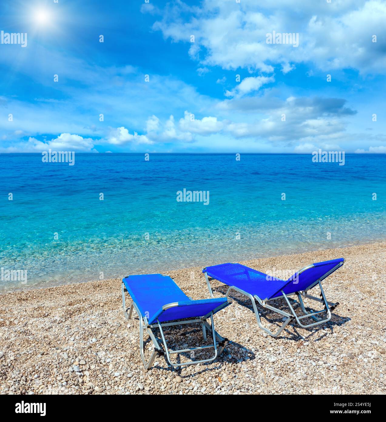Sommermorgen sonniger Kieselstrand mit Liegestühlen (Albanien). Zwei Aufnahmen fügen ein hochauflösendes Bild zusammen. Stockfoto