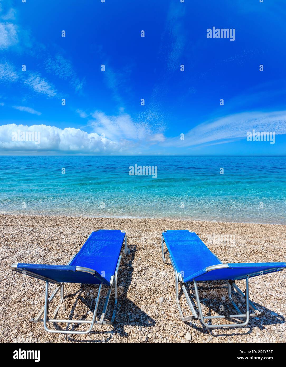 Sommer-morgen-Strand mit zwei Sonnenliegen und Wolken im Himmel (Albanien). Zwei Schüsse feststeppen Bild. Stockfoto
