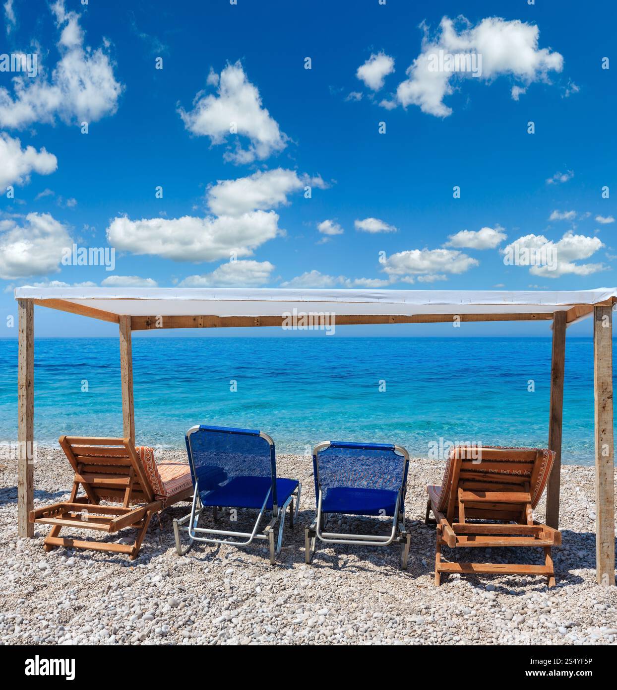 Sommer-morgen-Strand mit türkisblauem Wasser, blauer Himmel und Sonnenliegen (Albanien). Zwei Schüsse feststeppen Bild. Stockfoto