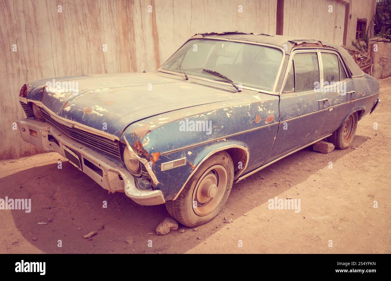 Ein alter rostiger Oldtimer, der in einer Wüstenstadt verlassen wurde. Altes, rostiges Auto Stockfoto