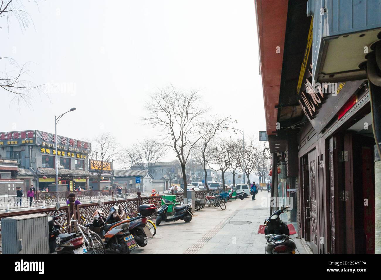 PEKING, CHINA - 19. MÄRZ 2017: Menschen und Parkplätze in der Liangshidian Street im Geschäftsviertel Dashilanr, südlich des Tiananmen-Platzes, westlich davon Stockfoto