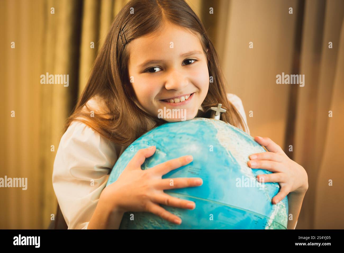 Porträt eines niedlichen Mädchens, das Hand auf dem Globus hält Stockfoto