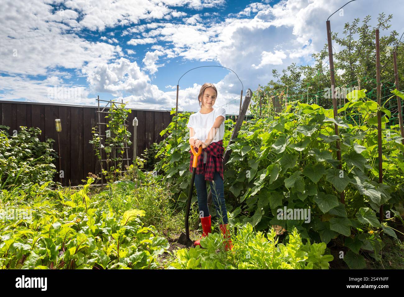 Lächelnde Frau, die im Garten arbeitet, an sonnigen Tagen Stockfoto