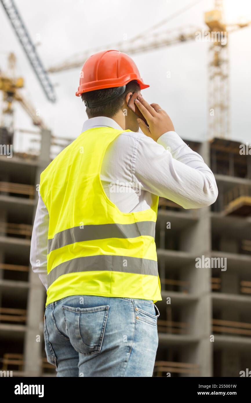Bauingenieur telefonisch und auf der Baustelle Stockfoto