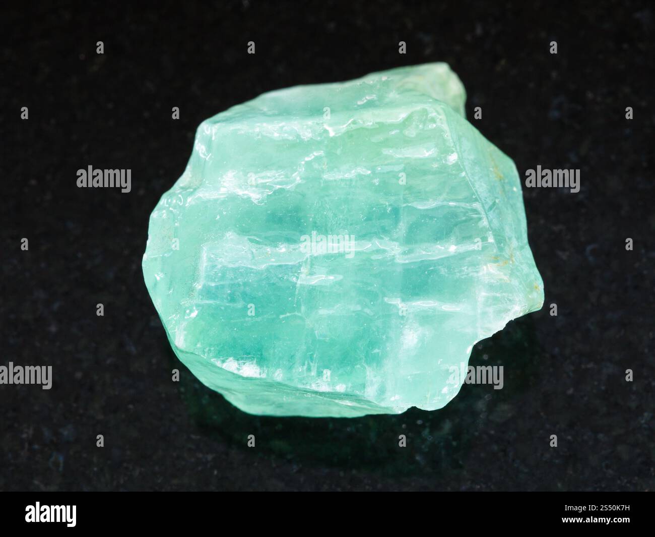 Makroaufnahmen von natürlichen Mineralgestein Muster - rohe grüne Calcit Stein auf dunklem Granit Hintergrund aus Mexiko Stockfoto