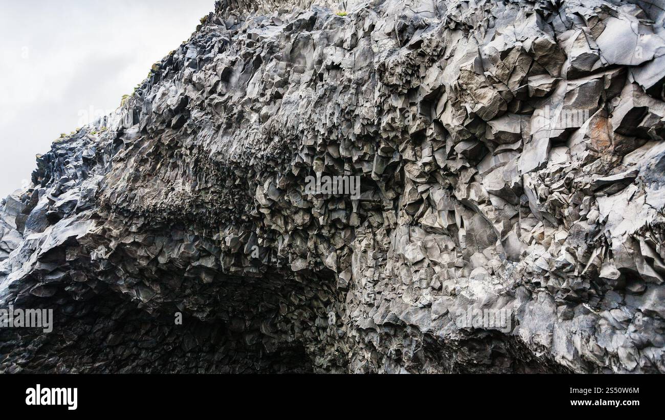 Reisen Sie nach Island - vulkanische Felsen von Reynisfjall werden über die Halsanefshellir-Höhle am Strand von Reynisfjara in Island, in der Nähe des Dorfes Vik i Myrdal on Stockfoto