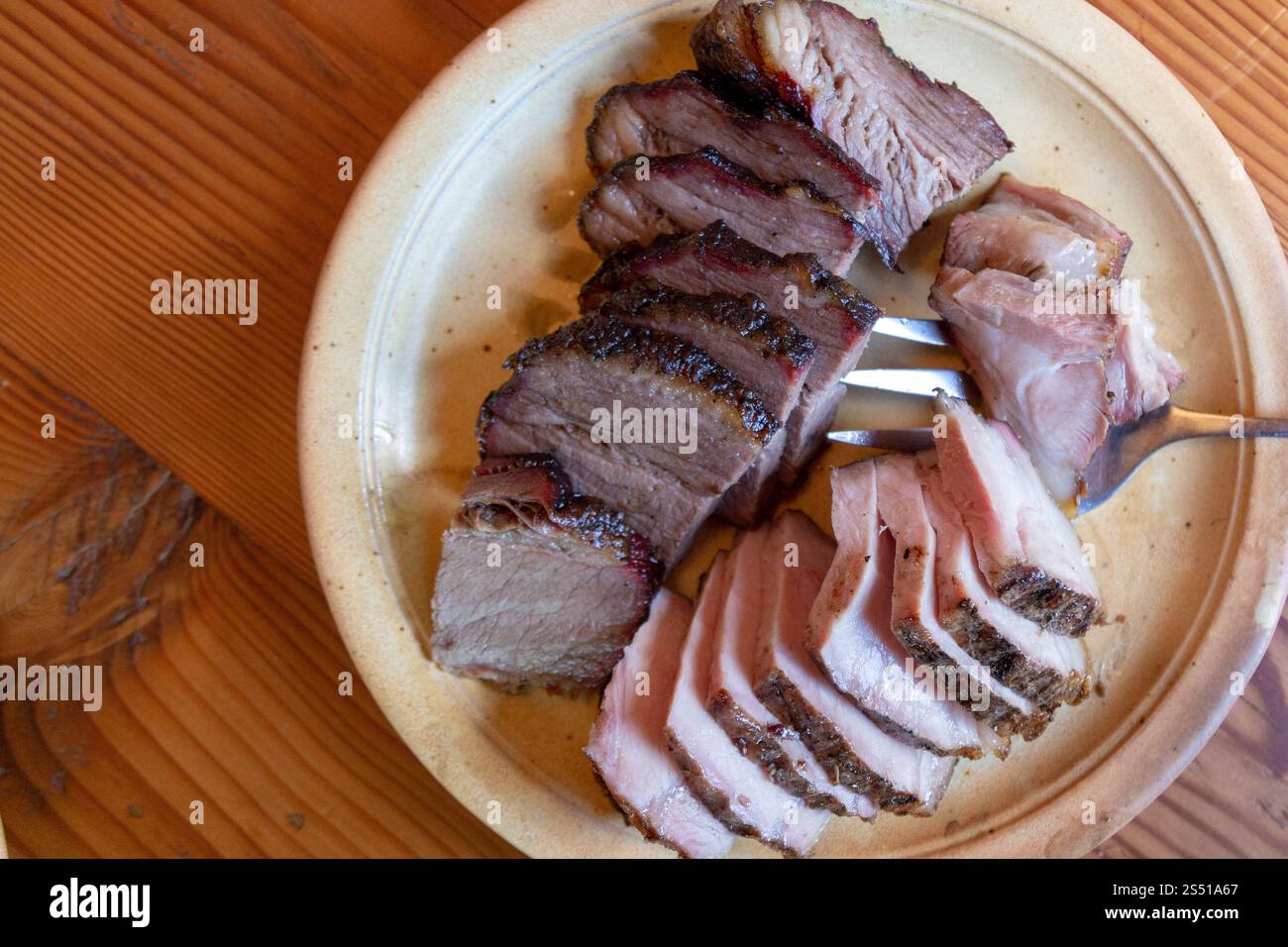 Schweinebraten und Rindfleisch in Scheiben serviert auf einem Teller für eine herzhafte Mahlzeit Stockfoto