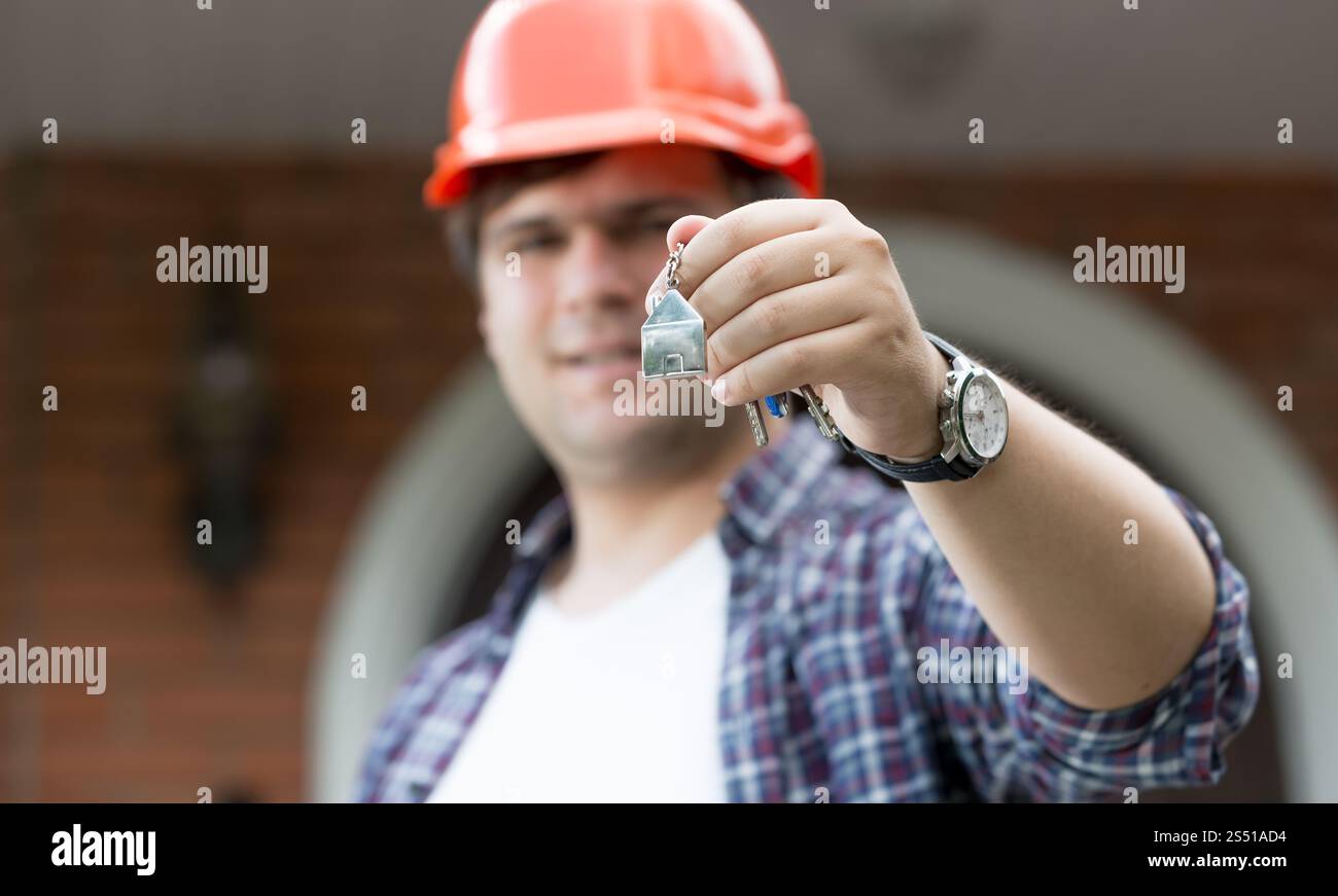 Nahaufnahme-Porträt eines männlichen Architekten, der Schlüssel aus dem neuen Haus in der Kamera zeigt. Porträt eines männlichen Architekten, der Schlüssel aus dem neuen Haus in der Kamera zeigt Stockfoto