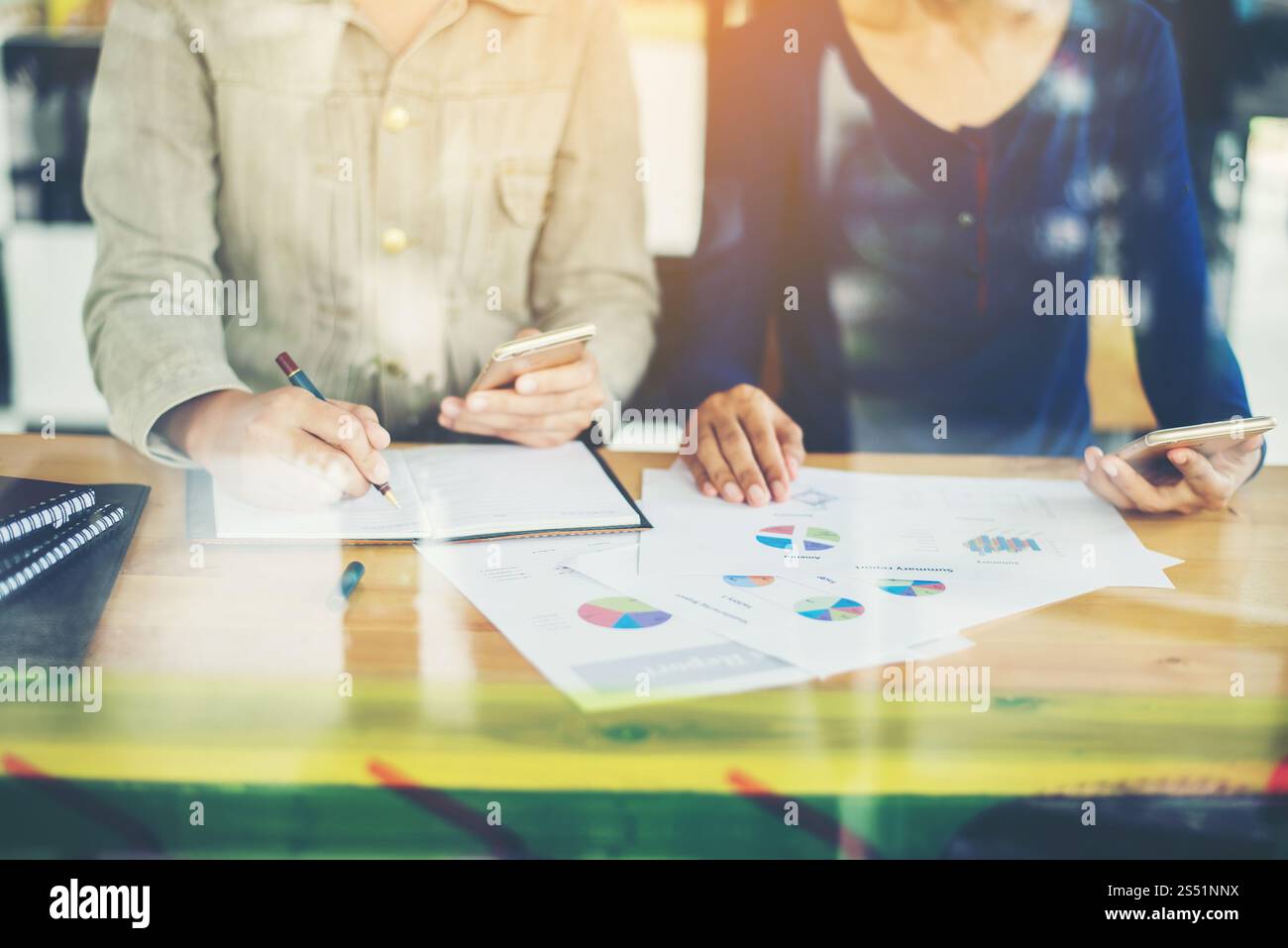 Nahaufnahme eines Geschäftsteams, das im Büro mit Fensterreflec arbeitet. Nahaufnahme des Geschäftsteams, das im Büro arbeitet, mit Fensterreflexion. Stockfoto