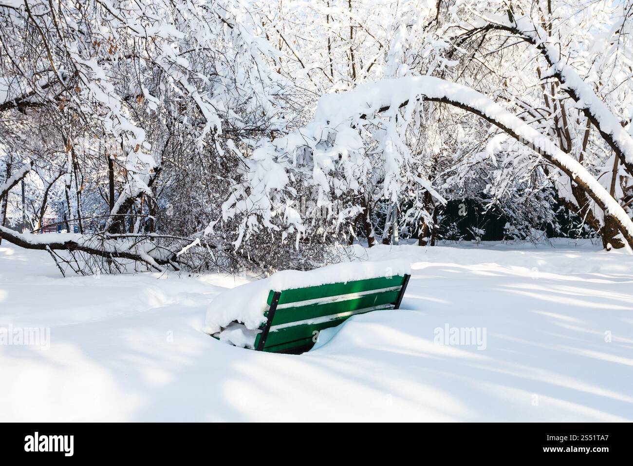 Verschneite Bank in der Verschneiten Urban Garden in Moskau Stadt im sonnigen Wintermorgen Stockfoto