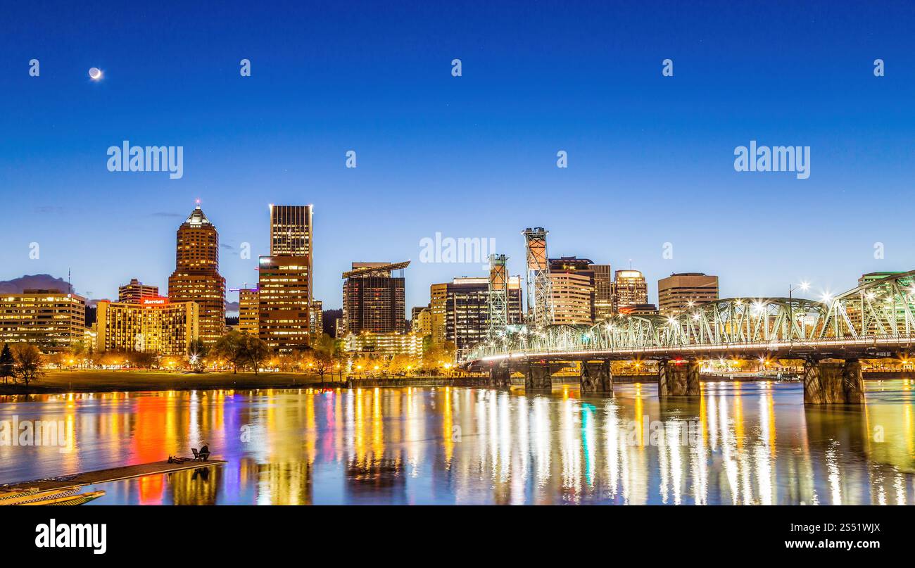 Malerischer abendlicher Blick auf die Skyline einer Stadt mit Waterfront und beleuchtetem Hawthorne, Brücke Stockfoto