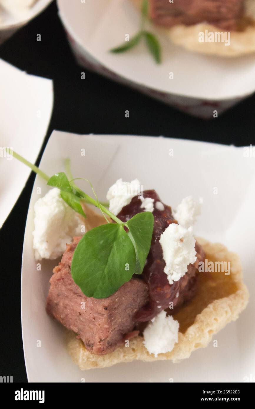 Appetitliches Fleischgericht mit Gourmet-Beilagen und frischen grünen Blättern Stockfoto