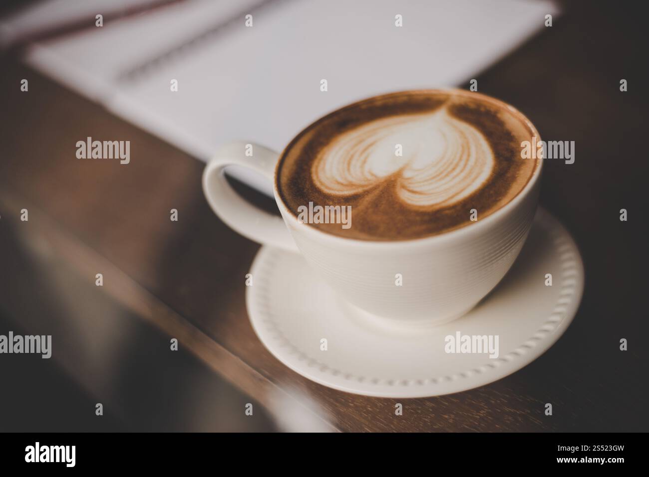 Vintage-Ton mit heißem Kaffee Latte Art in Herzform in Tasse auf ta. Vintage-Ton mit heißem Kaffee Latte Art in Herzform in Tasse auf dem Tisch. Stockfoto