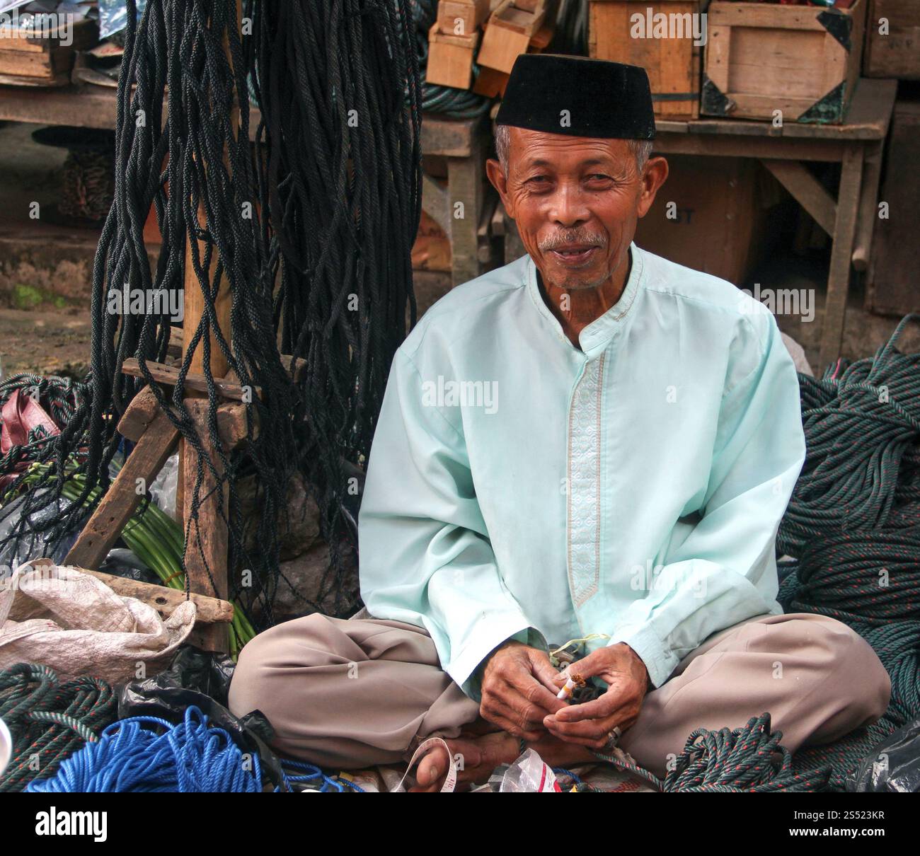 Ein älterer muslimischer Mann, der Seile auf einem traditionellen Markt in Bukittinggi, West Sumatra, Indonesien verkauft. Stockfoto