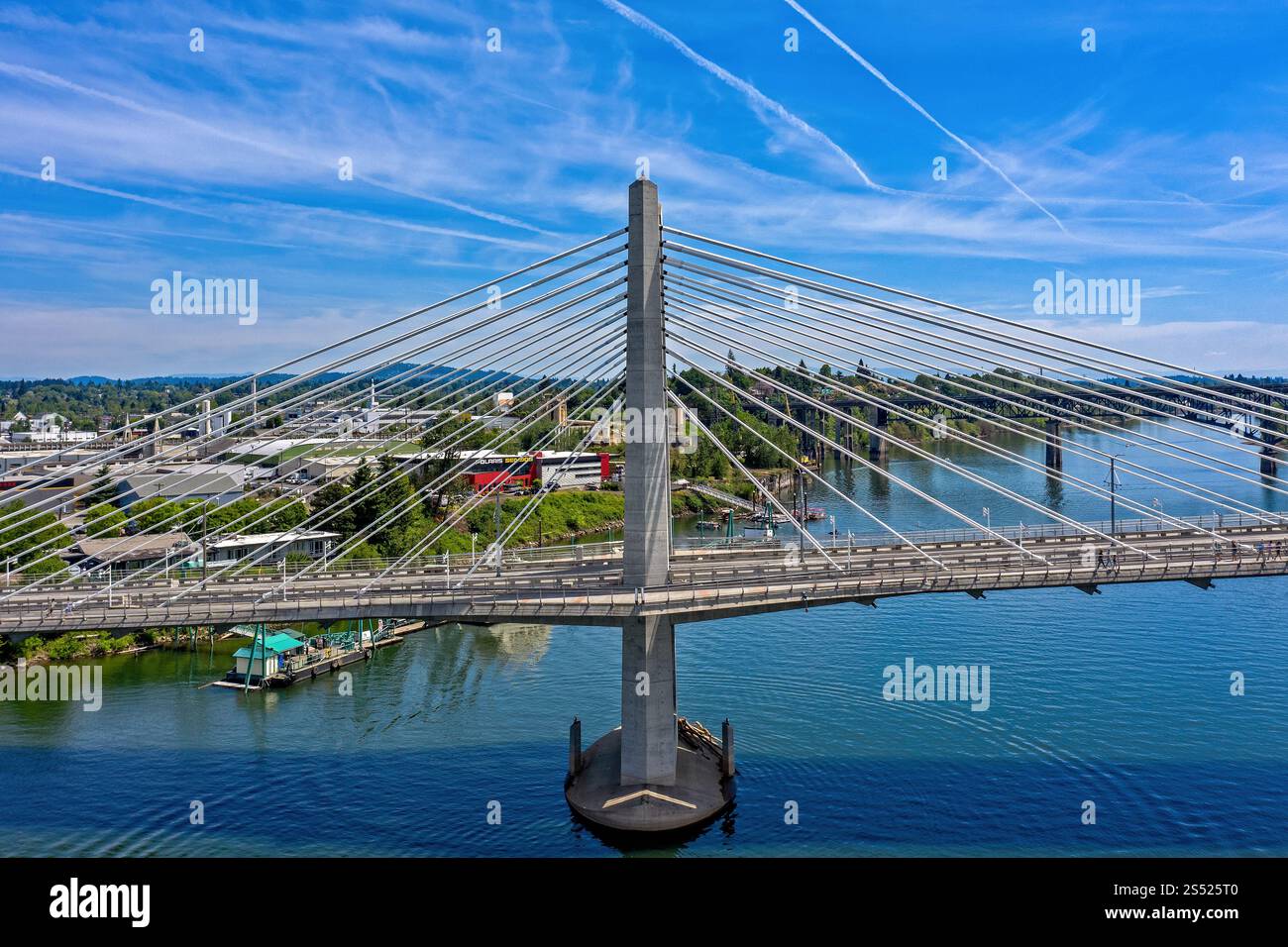 Moderne, mit Kabel überdachte Tilikum Bridge über einen ruhigen Willamette River an einem hellen Sommertag in Portland, Oregon Stockfoto
