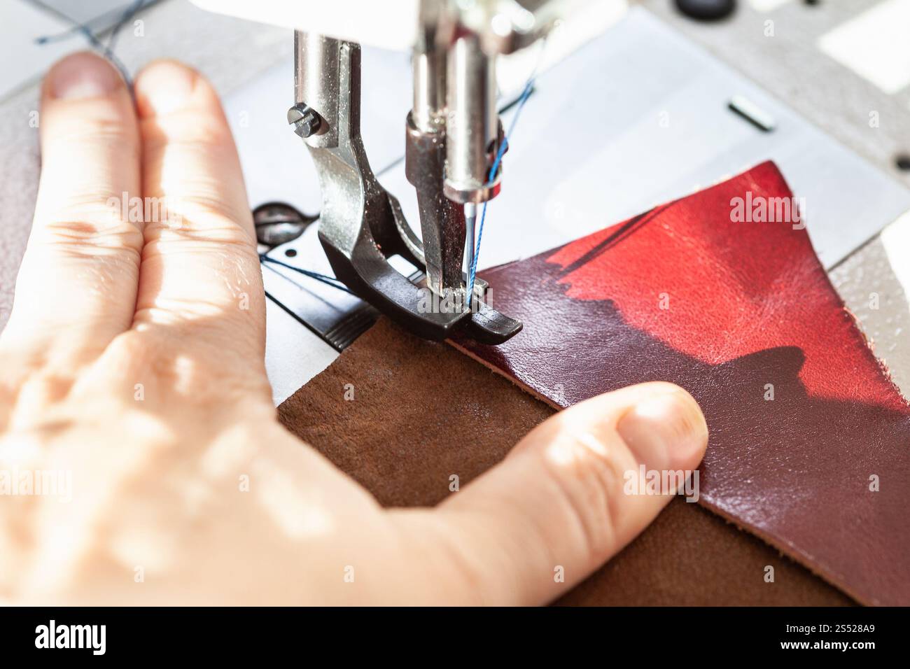 Die Schneiderin näht Lederstücke auf der Nähmaschine Nahaufnahme Stockfoto