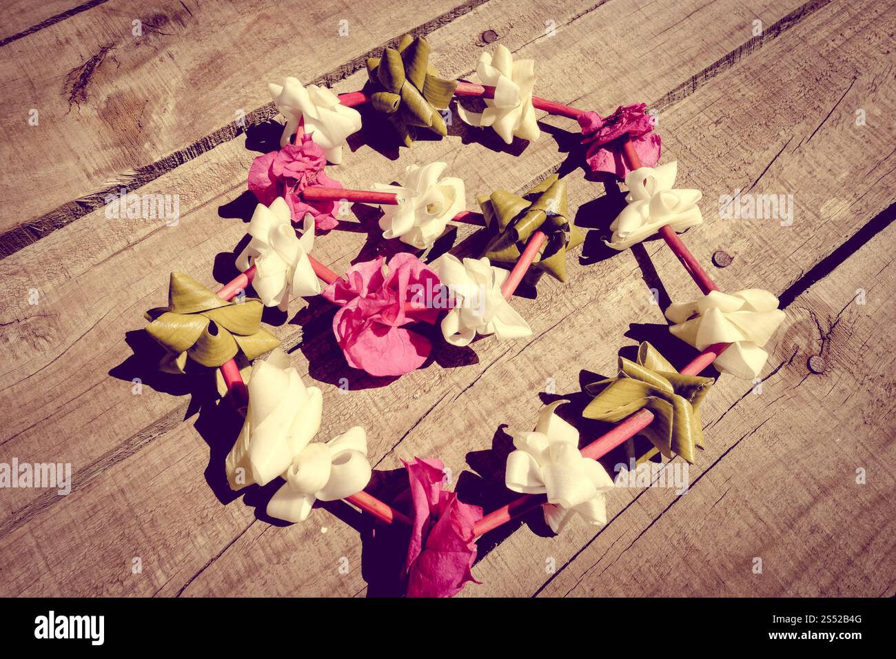 Traditionelle polynesische Blumenkette auf hölzernem Hintergrund. Polynesische Blumenkette Stockfoto