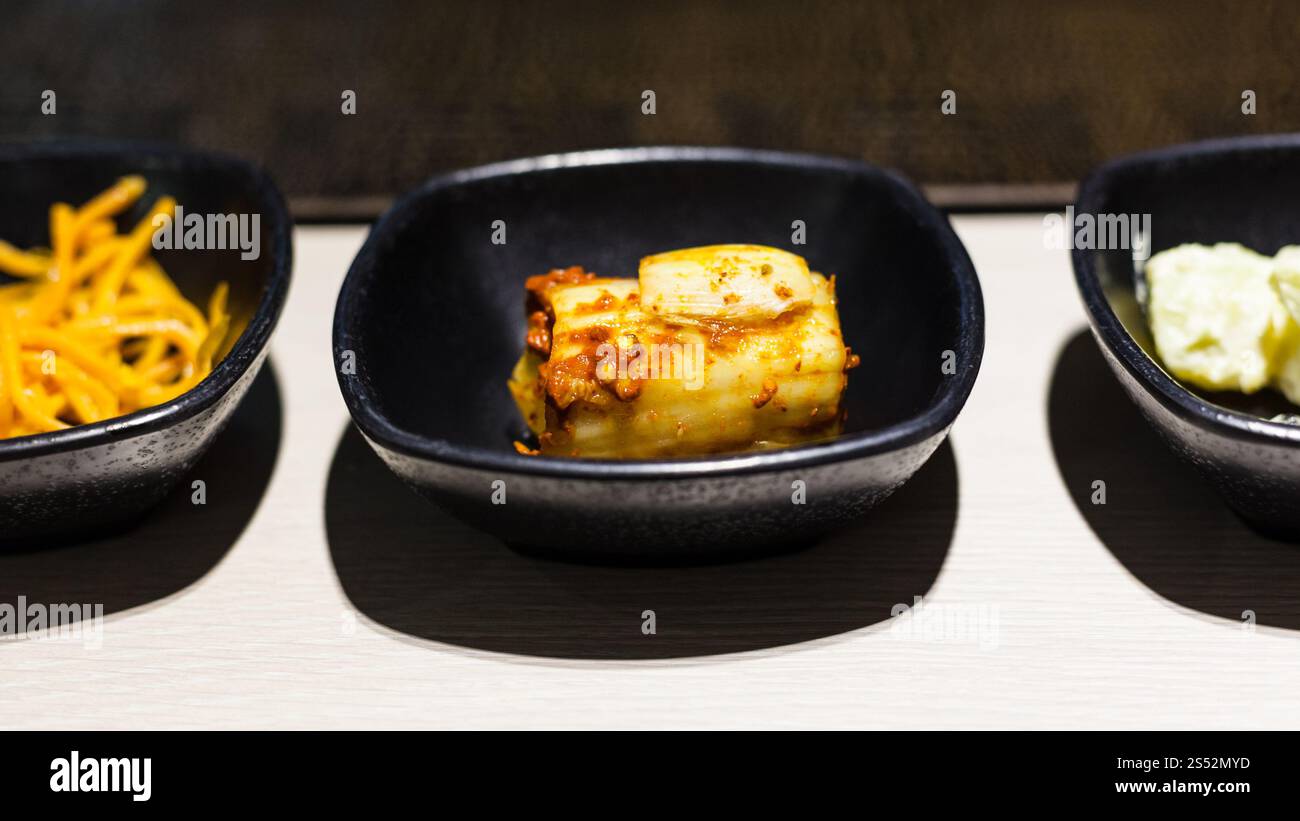 koreanische Küche: Kimchi-Vorspeise und andere Banchan-Beilagen in Schüsseln im lokalen Café Stockfoto