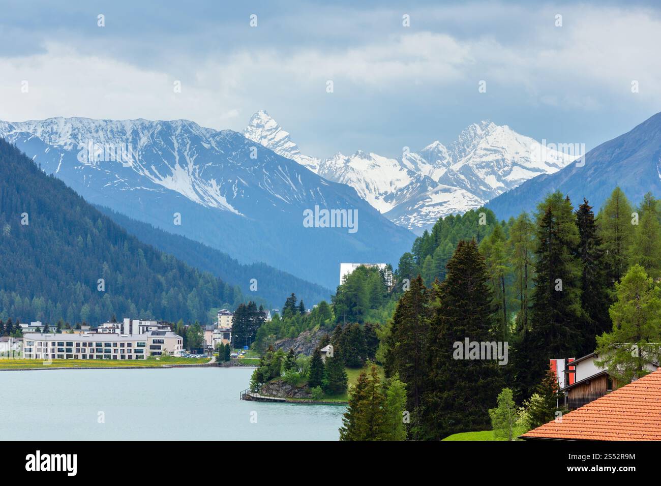 Sommer Landschaft mit Davos See, die Stadt Stadtrand und Berge mit Schnee in weit (Schweiz). Stockfoto