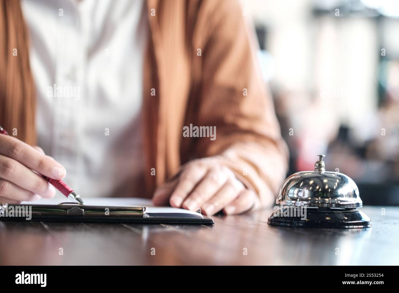 Frau Gast an der Rezeption des Hotels, die eincheckt Stockfoto