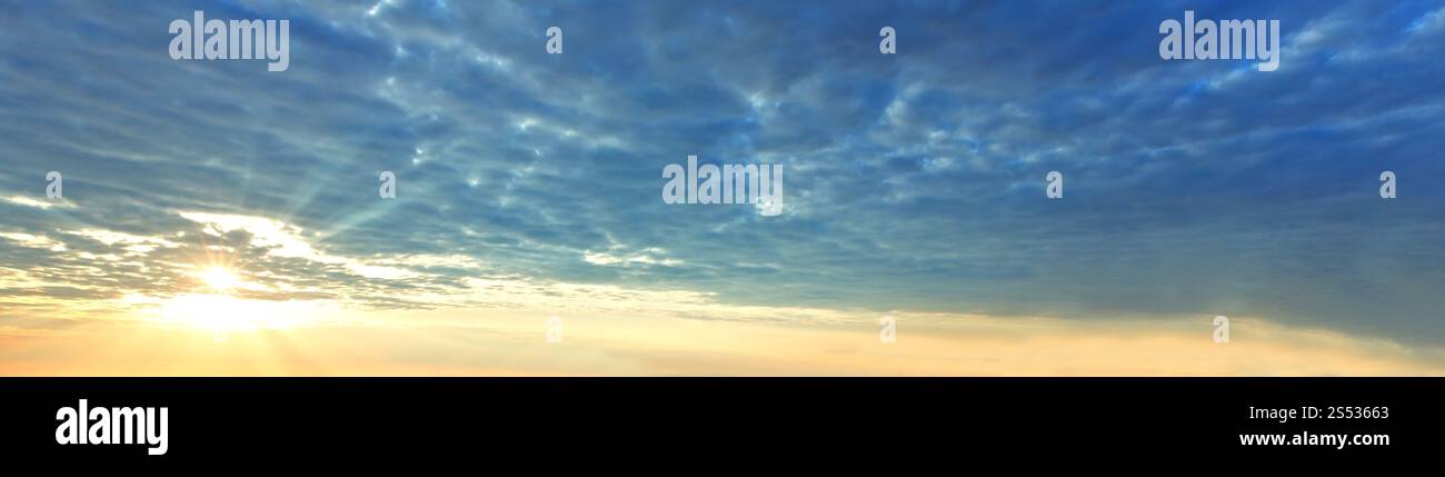 Sommermorgen Sonnenaufgang bewölkter Himmel mit Sonnenschein Panorama Hintergrund. Stockfoto