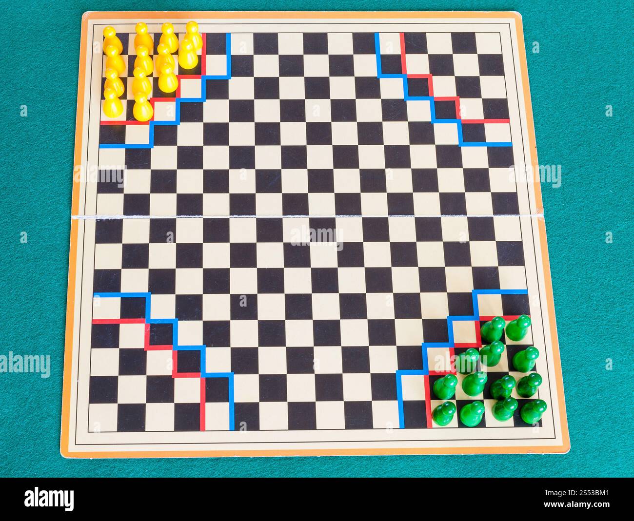 Setup für zwei Spieler auf dem karierten Gameboard des Halma Strategiebrettspiels auf grünem Baize-Tisch. Das Brettspiel Halma wurde von George Howard Monks erfunden Stockfoto